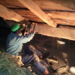 Stone Store Timber framer, Scott Galliford, repairs a cracked purlin in the Stone Store attic.
